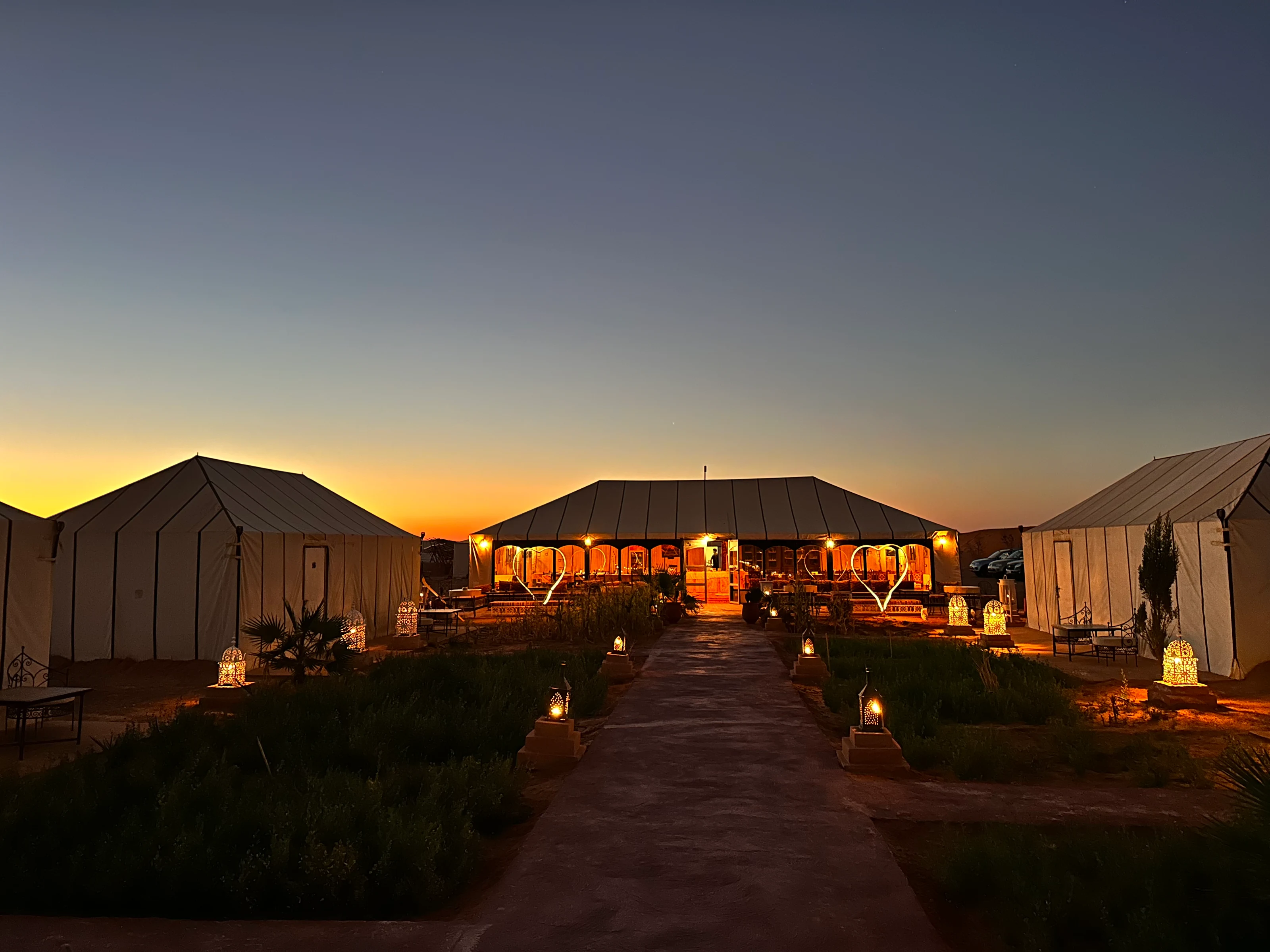 Un camino entre las jaimas de Golden Camp al atardecer