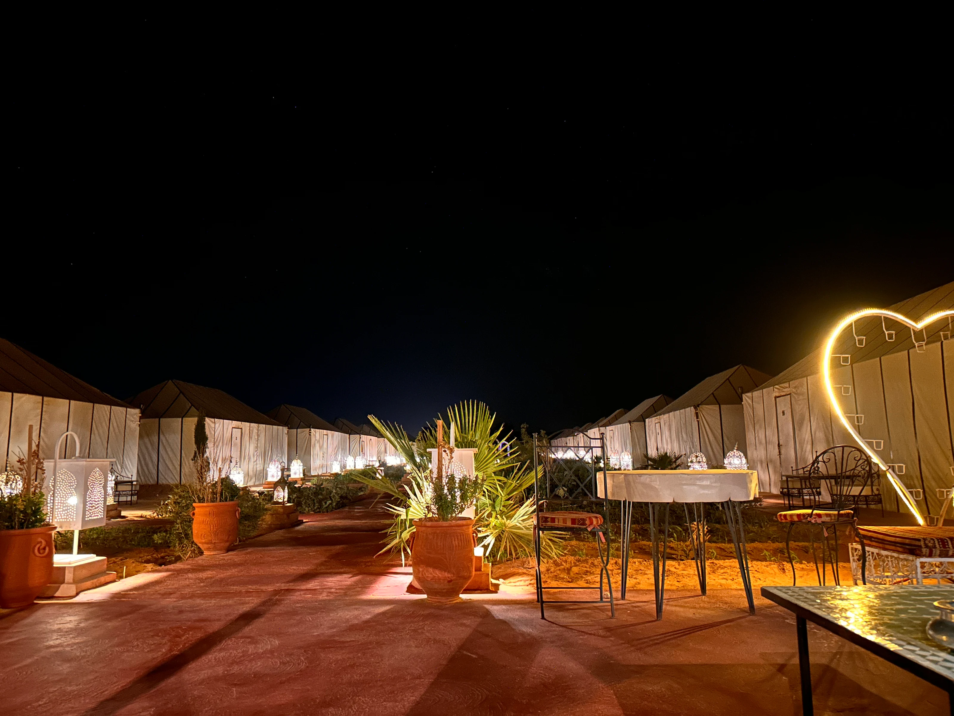 Jaimas y asientos al aire libre iluminados por la noche en Golden Camp