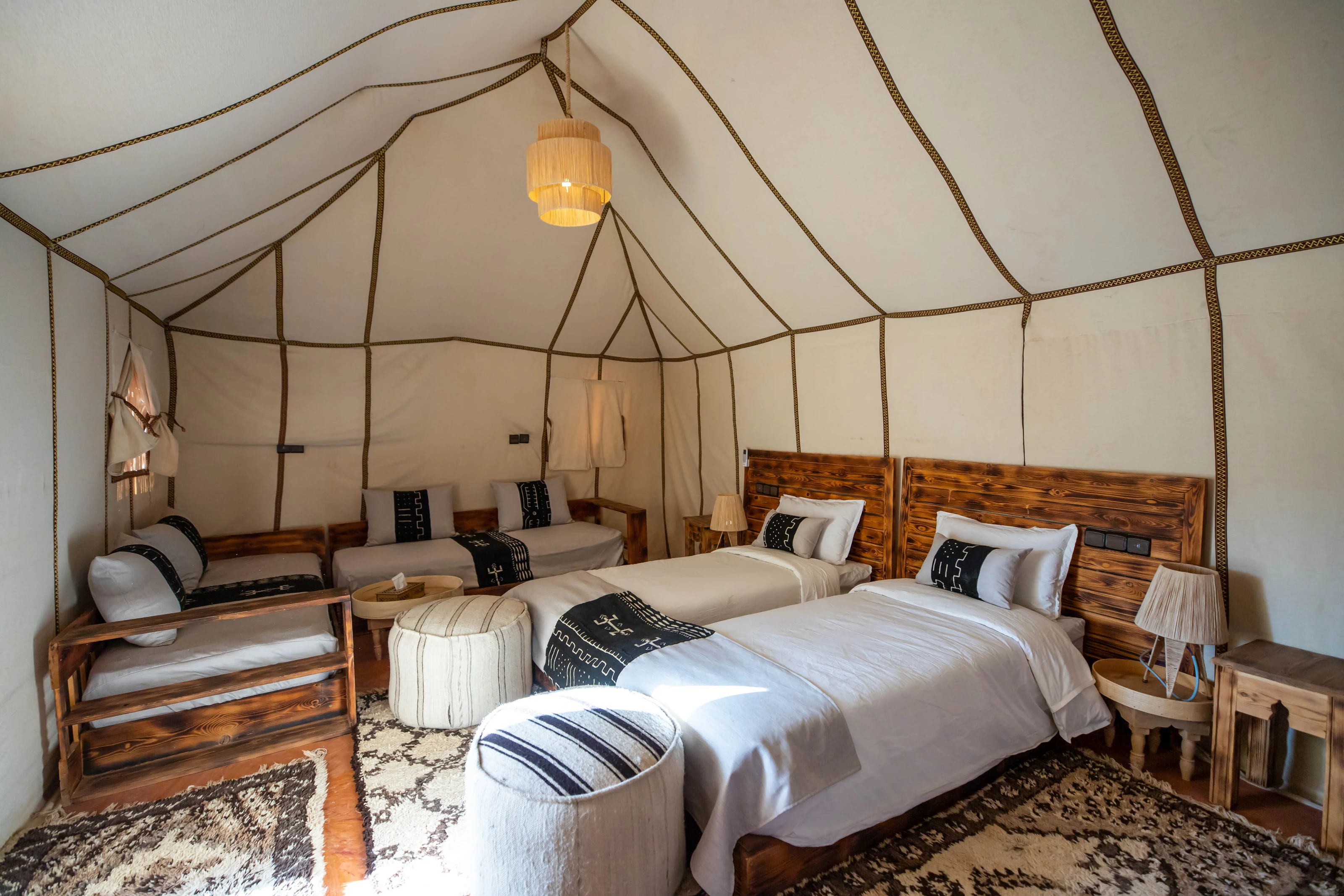 Dos camas individuales y una zona de estar en una jaima de Golden Camp